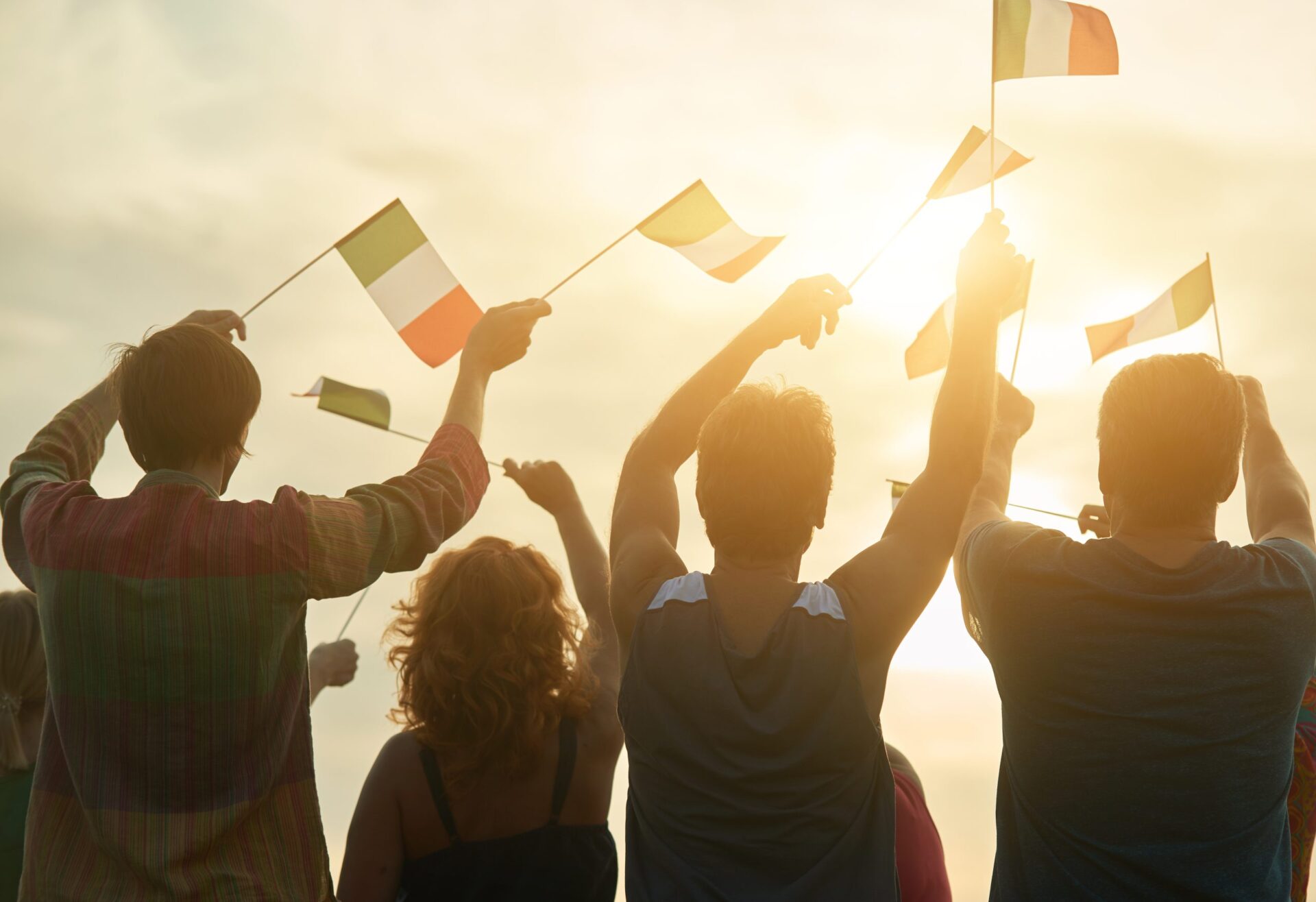 Waving italian flags outdoors. Patriotic italilan family, rear view.